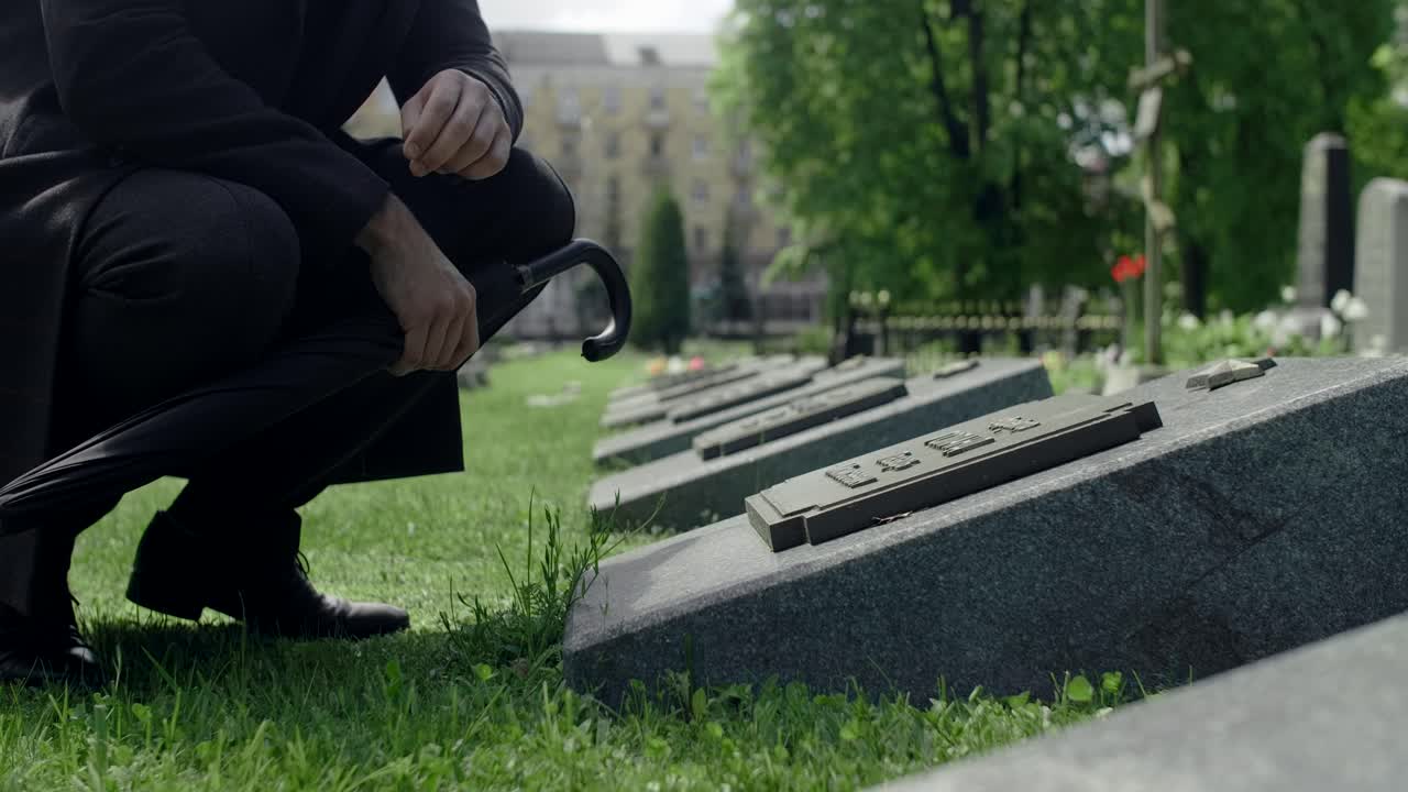 Man Kneeling at a Cemetery