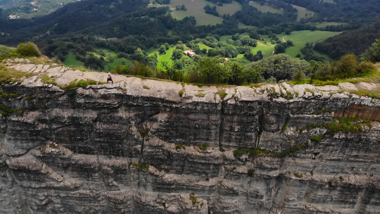 antena: toma cenital de un hombre con una maleta caminando sobre un acantilado