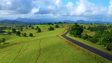 Carretera-Asfaltada-Vacía-A-Través-De-Verdes-Colinas-Durante-El-Día-En-Atherton,-Mesetas,-Australia