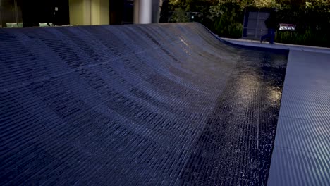 water cascades over a dark, textured pathway