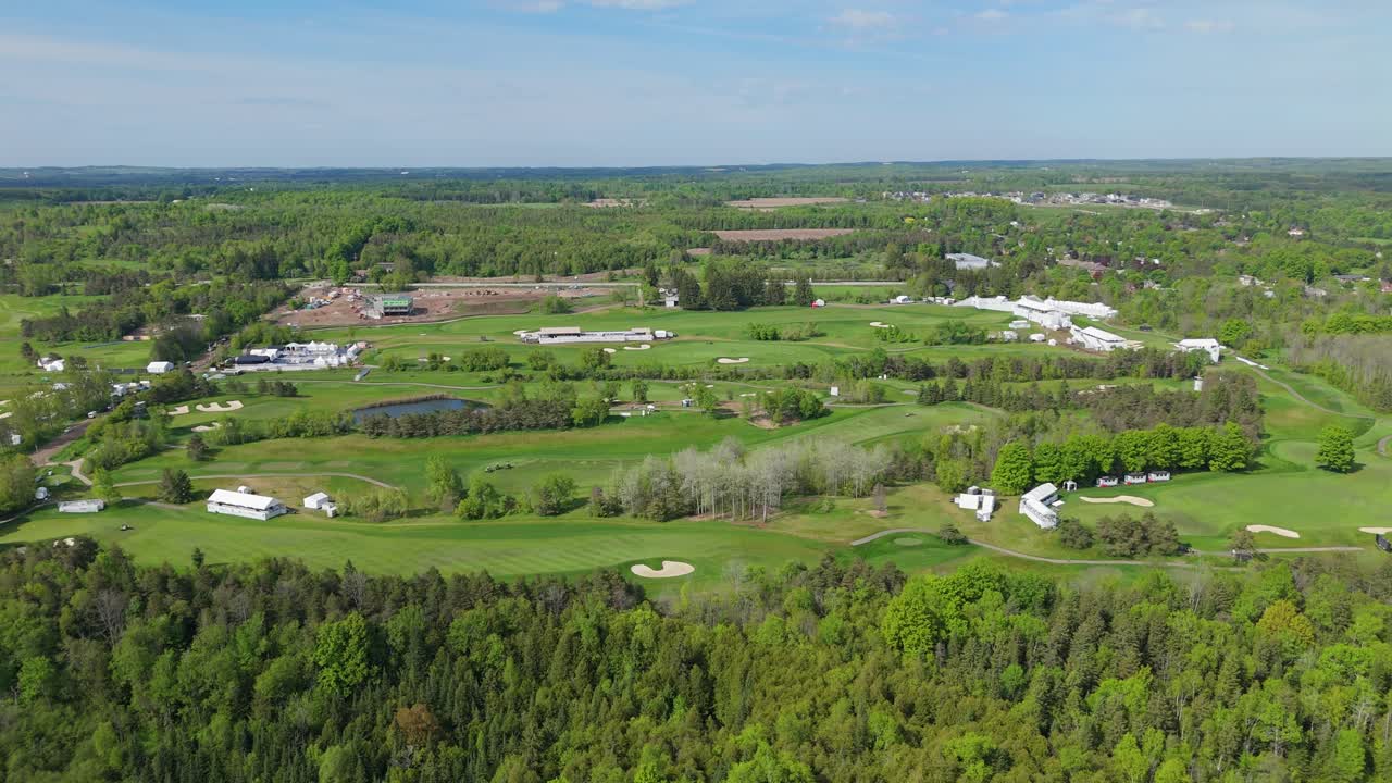Osprey Valley golf course and green forest in Canada, wide aerial pan