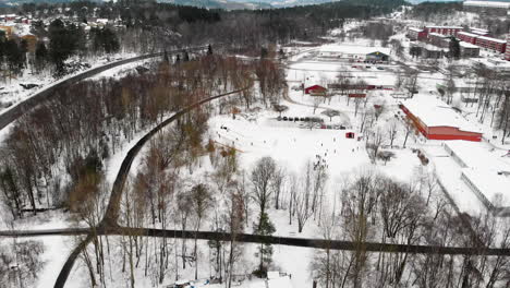 aerial view of elementary kids at the school yard running and riding snow sled at winter