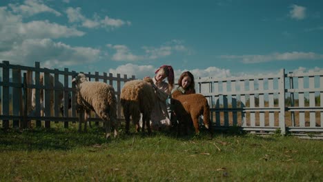 two girls interacting with sheep on a farm