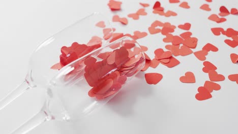 champagne glasses with paper hearts on pink background at valentine's day