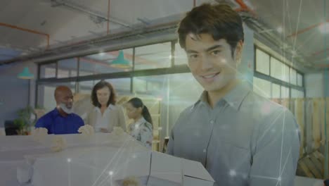 Animation-of-network-of-connections-against-portrait-of-asian-man-smiling-at-office