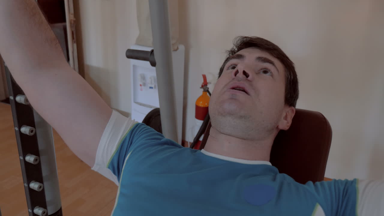 체육관 에서 벤치 프레스 를 하는 남자