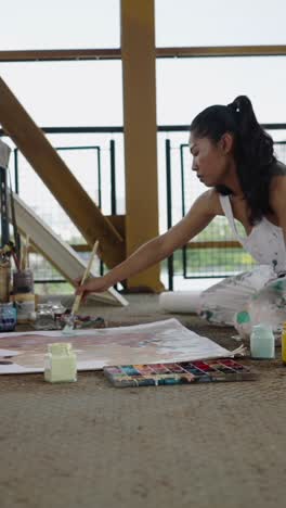 a woman painting on a canvas