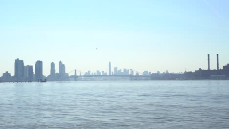 williamsburg bridge in the distance with a helicopter approaching