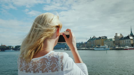 a young tourist photographs beautiful views of stockholm with a retro camera