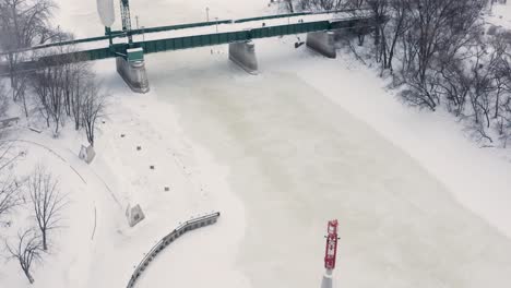 aerial tilt up over two joining rivers to reveal the city of winnipeg manitoba during an ice storm