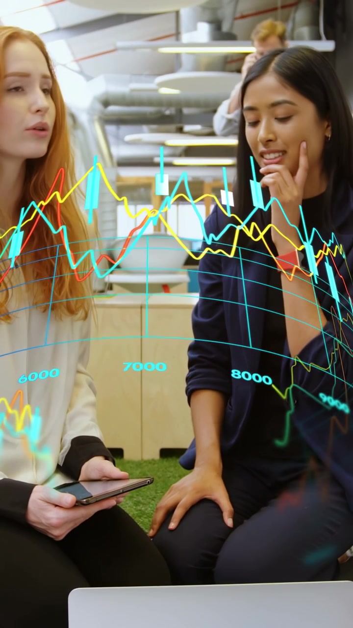 Vertikal video: Kvinnen til venstre taster på telefonen og viser AR-finansdiagrammer over bærbar PC for analyse.