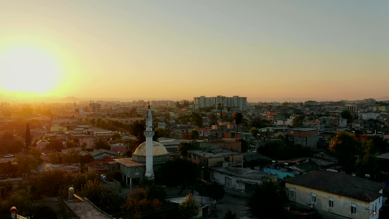 vuelo sobre la ciudad musulmana con minarete de la mezquita y edificios residenciales.
