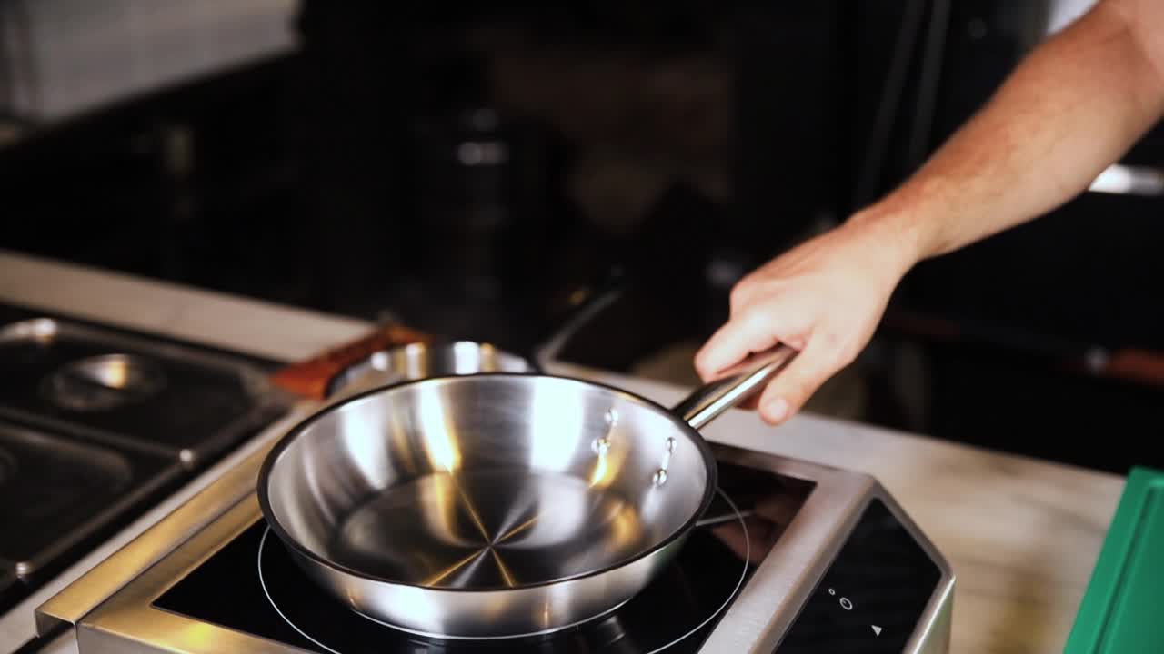 Chef cooking with a pan on a hot plate