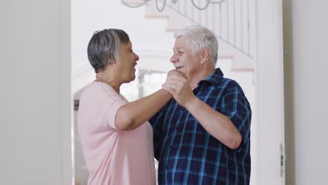 Happy-diverse-senior-couple-having-fun-dancing-together-at-home,-slow-motion