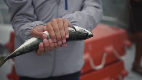 young fisherman holds caught fish