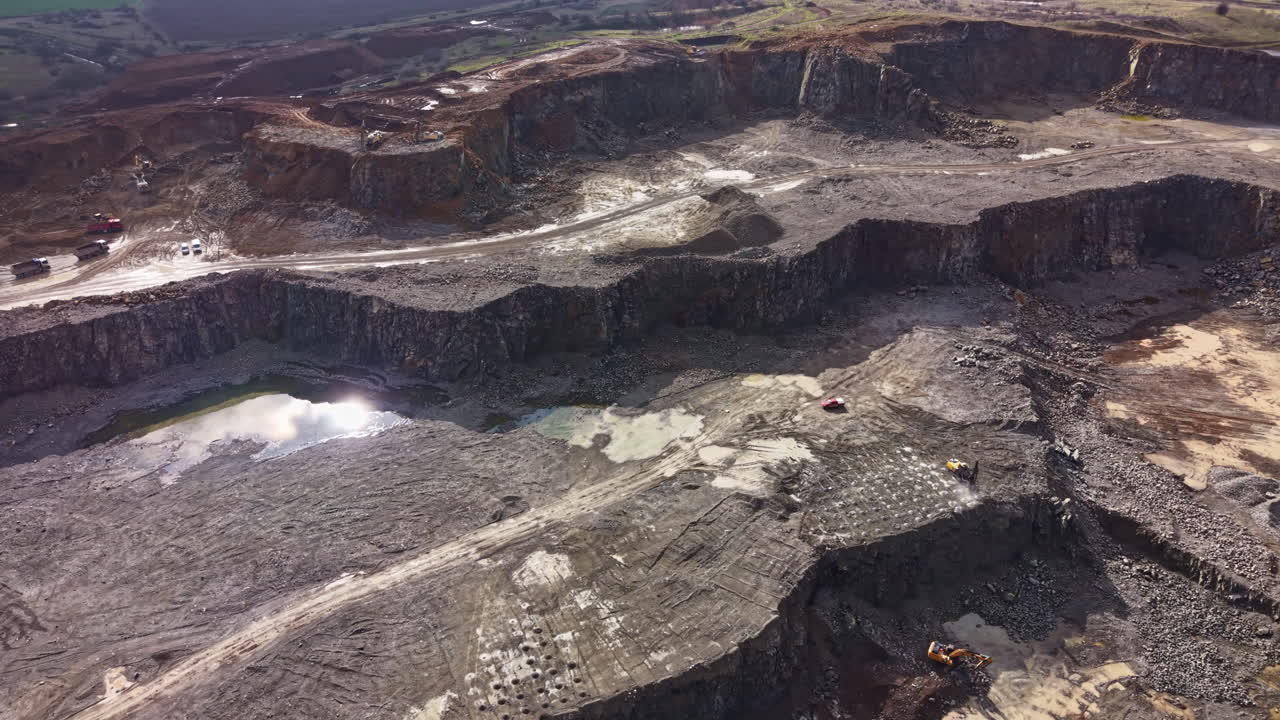 Granite quarry located in a rural area showing large rock formations and machinery at work during daylight hours