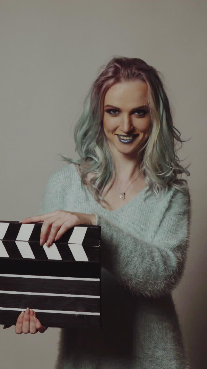 Film production and movie making concept. Portrait of young pretty woman with clapperboard.