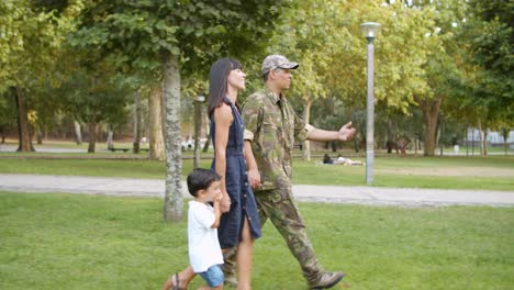 glücklicher soldat, der mit seiner familie die freizeit im park genießt