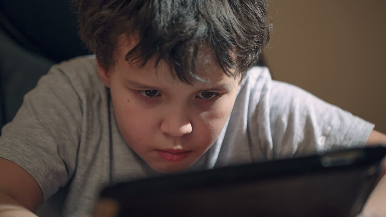 niño ocupado con su touchpad