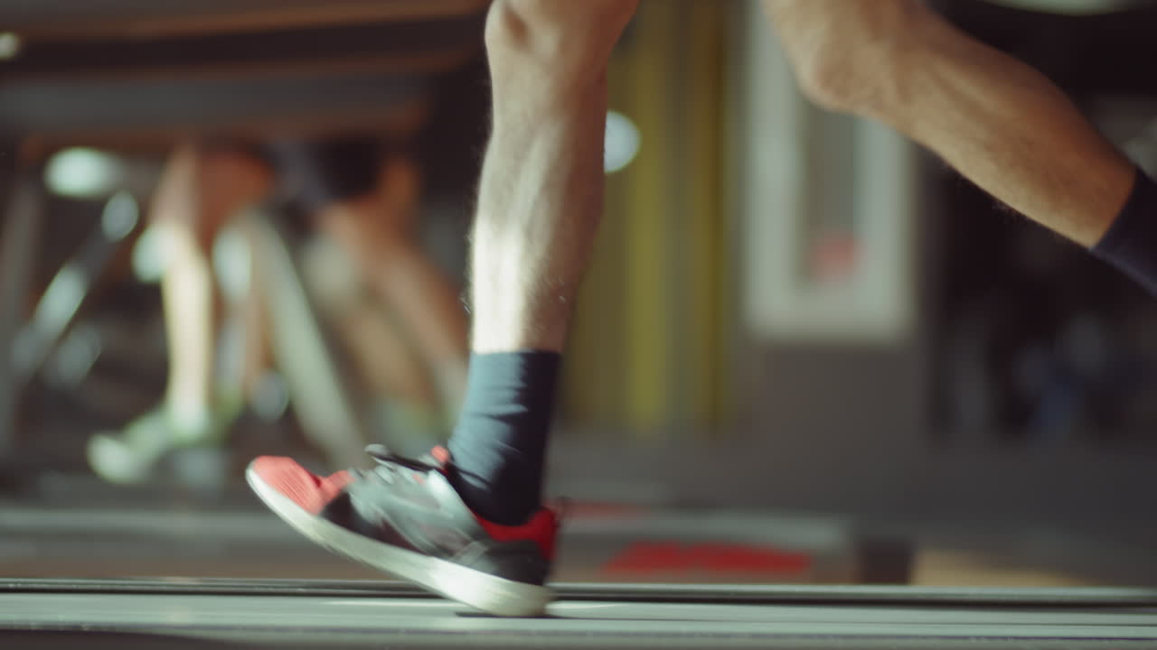 Legs of Man Running on Treadmill in Gym
