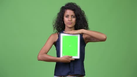 young beautiful hispanic businesswoman showing digital tablet