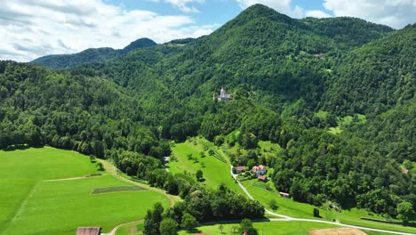 aerial drone fly above žovnek castle green mountain landscape slovenia tourism landmark in warm summer daylight