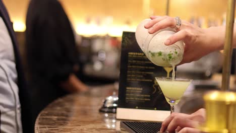 bartender garnishing a cocktail with precision