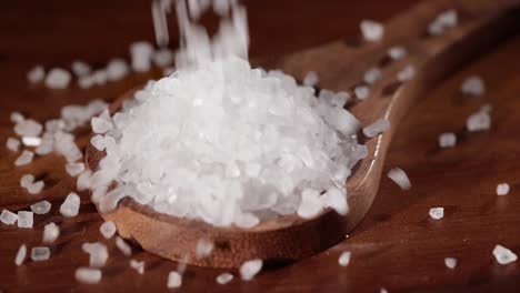 Sea-salt-crystals-closeup-in-wooden-spoon-on-a-kitchen-table.