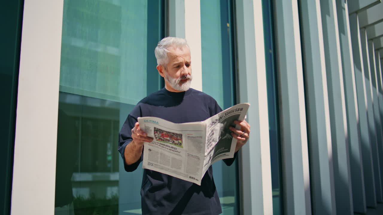 시내에서 커피를 마시는 노인 사업가. 사려 깊은 고령자 신문 읽기