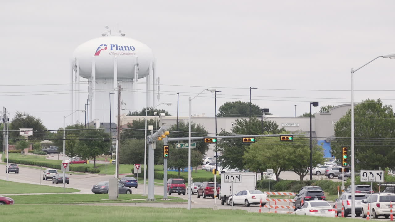 plano, torre de agua de texas junto a una carretera concurrida que conduce a la ciudad