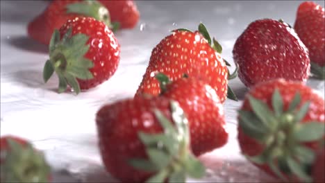 strawberries rolling down on white background. slow motion