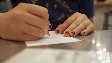 primer plano de una mano escribiendo y dibujando en un libro de bocetos