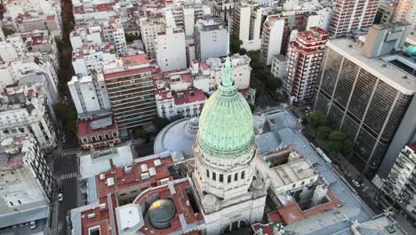 ángulo alto aéreo del palacio de congresos argentino cúpula de bronce verde rodeada de edificios de buenos aires a la hora dorada