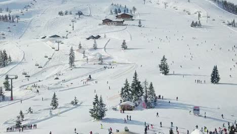 4k drone aerial of people doing winter sport in the alps, flachau, austria