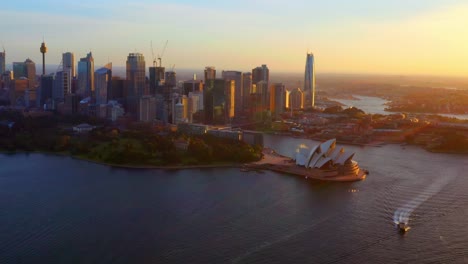 Umlaufende-Luftaufnahme-Von-Sydney-Cbd-Und-Opernhaus-Mit-Goldenen-Sonnenstrahlen---Nsw-Australien