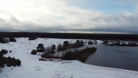 vista aérea giratoria sobre el lago belga dentro del paisaje forestal cubierto de nieve, paisaje de invierno