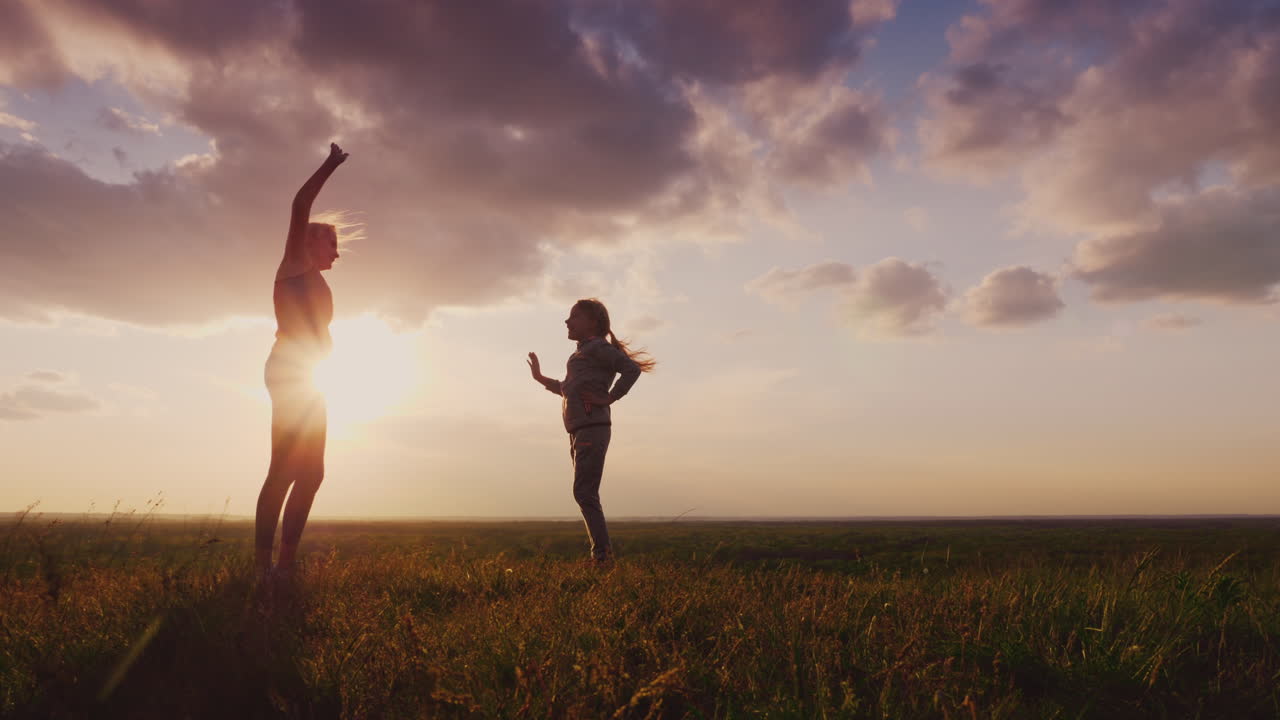 자연 속에서 피트니스를 하는 아이를 둔 젊은 여성의 실루엣