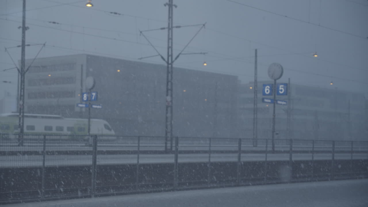 눈이 내리는 겨울날 배경에 큰 건물이 있는 헬싱키 기차역의 정적 와이드 샷