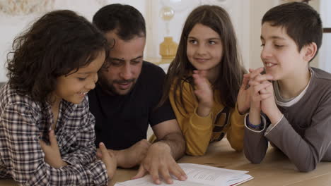 padre caucásico alegre y niños estudiando en casa.