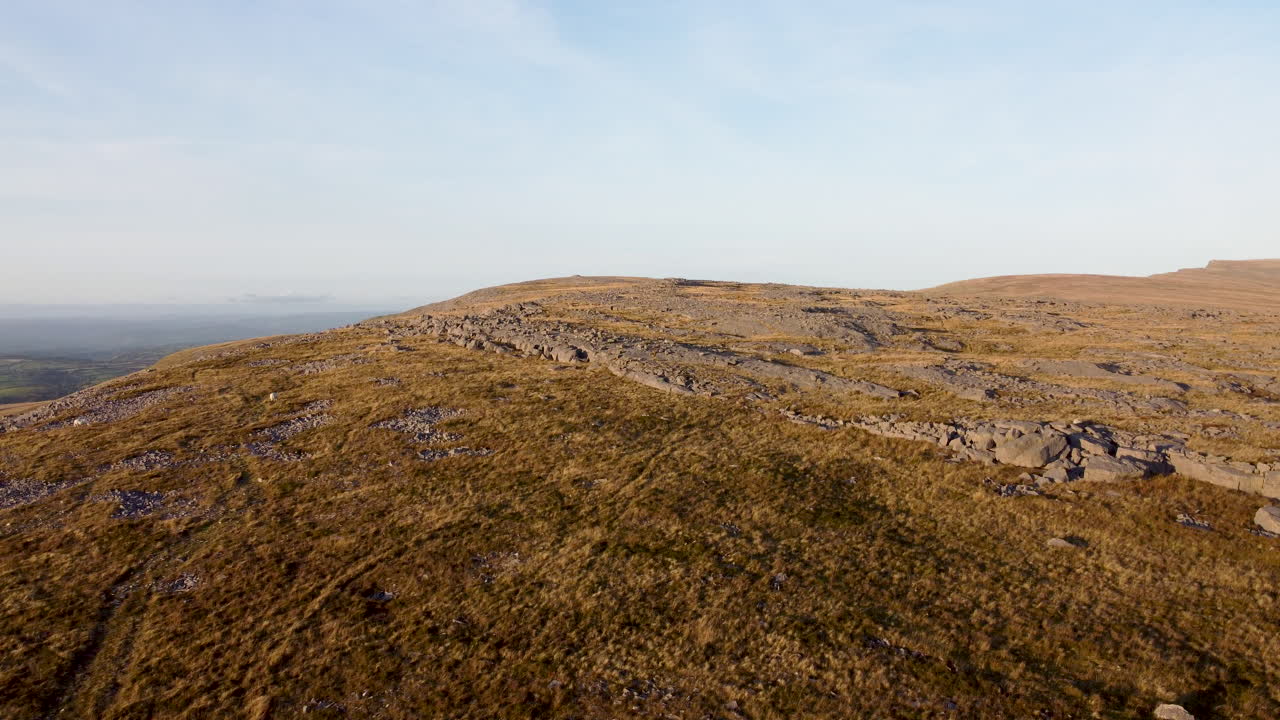 drone aéreo 4k tiro subiendo rápidamente sobre el paisaje de montaña rocosa con cielo azul en brecon beacons, reino unido