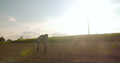 Angry-Farmer-Throwing-Hoe-On-Field-In-Farm