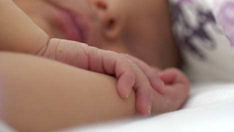 primer plano de la mano y los dedos del bebé recién nacido durmiendo