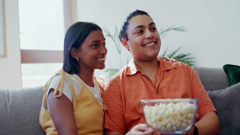 pareja, palomitas de maíz y risa para ver la televisión en el sofá