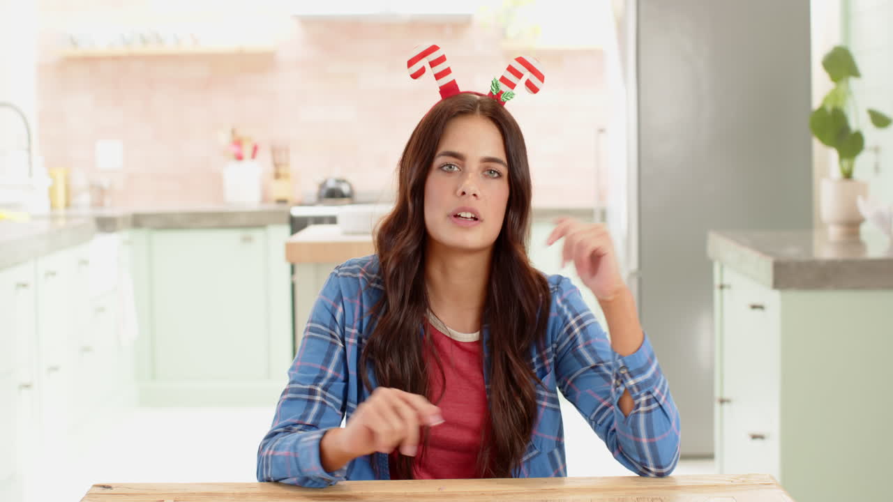 Christmas time, Woman wearing festive headband talking at kitchen table, enjoying holiday spirit