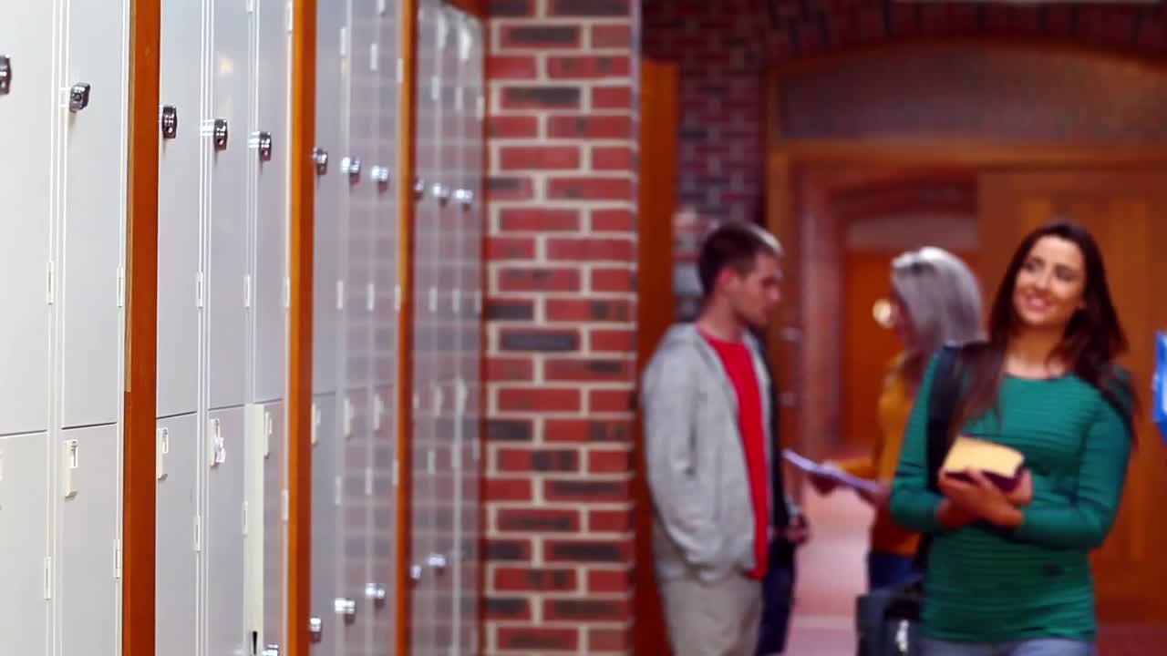 두 명의 학생들이 웃고 복도에서  ⁇ 고 있습니다.