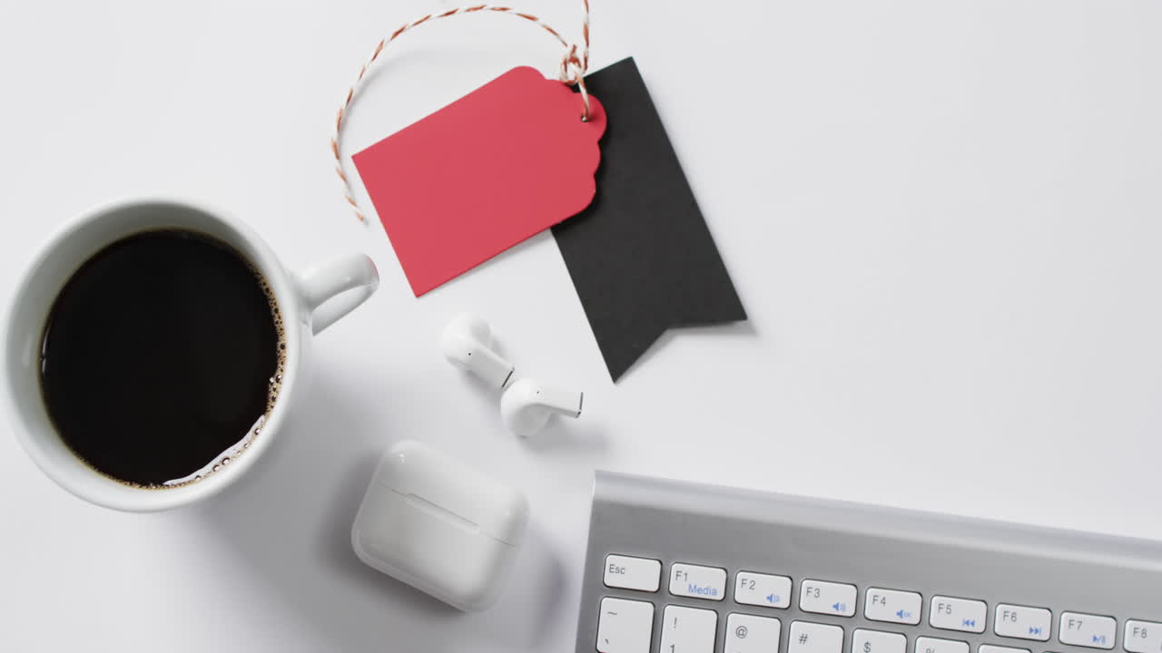 video del teclado de la computadora, la taza de café, los auriculares, las etiquetas de regalo con espacio de copia en fondo blanco