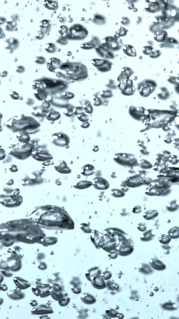 Numerose bolle d'aria che salgono in un liquido limpido su sfondo azzurro chiaro