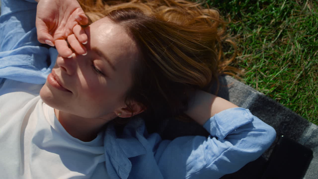 ⁇ 은 날 태양에 미소 짓는 아름다운 소녀. 녹색 공원 풍경에 부드러운 여성