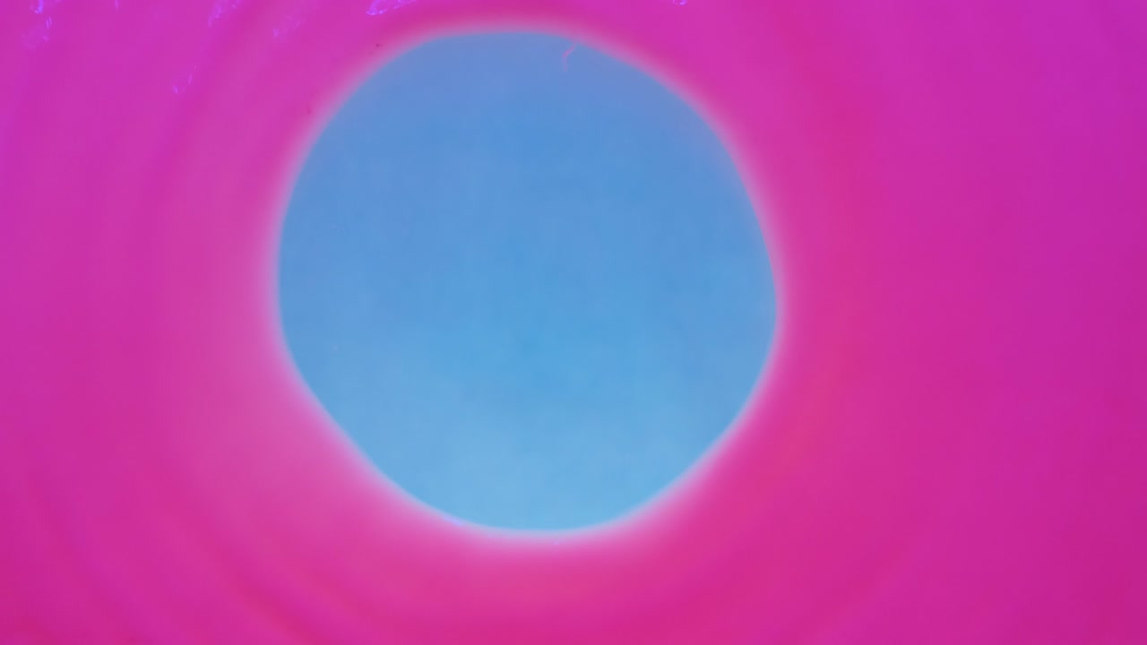 바람이 형광 페인트의 중앙으로 불어서 원 모양으로 불어 니다. 위쪽 뷰. 색상 추상적인 배경.