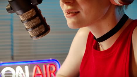 woman broadcasting live in a studio with an "on air" sign